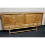 A blonde oak four door sideboard