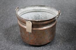 An antique copper swing handled cooking pot