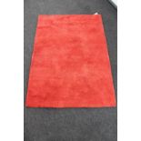 A contemporary red woollen rug