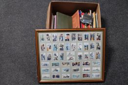 A box of cigarette card catalogues, tea card albums and tea cards,