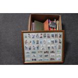 A box of cigarette card catalogues, tea card albums and tea cards,