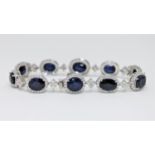 An 18ct white gold sapphire and diamond tennis bracelet featuring 10 oval cut Kashmiri sapphires 24.