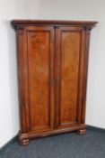 A continental walnut corner cupboard on bun feet