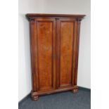 A continental walnut corner cupboard on bun feet