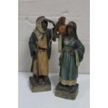 Two antique pottery figures depicting an Arabic gentleman and lady with water jug