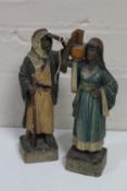 Two antique pottery figures depicting an Arabic gentleman and lady with water jug