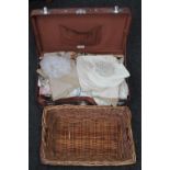 A mid 20th century luggage case containing table linen,