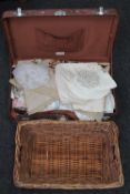 A mid 20th century luggage case containing table linen,