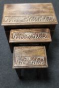 A nest of three carved hardwood tables depicting elephants