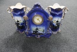 A 19th century three piece pottery clock garniture depicting windmills