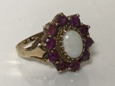 An opal and ruby cluster ring mounted in yellow gold