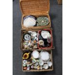 Two boxes and a wicker basket of tea china, figurines, wall plates,
