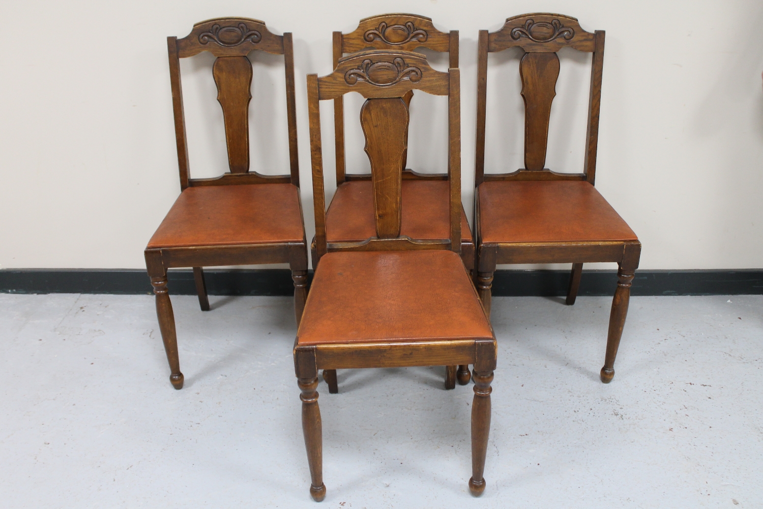 A set of four 20th century oak dining chairs with leather seats