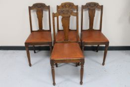 A set of four 20th century oak dining chairs with leather seats