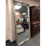 An ornate silvered leaning mirror,