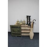 A set of pine open shelves together with a wicker vase containing walking sticks,