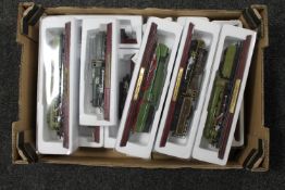 A box of twelve Atlas model trains on wooden stands