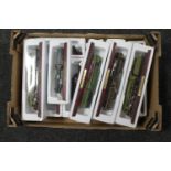 A box of twelve Atlas model trains on wooden stands