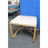 A square marble topped table on a bamboo base