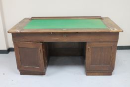 A mid 20th century oak twin pedestal desk with slide out top panel