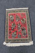 A fringed floral Persian hearth rug