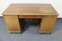 A mid 20th century continental walnut twin pedestal writing desk