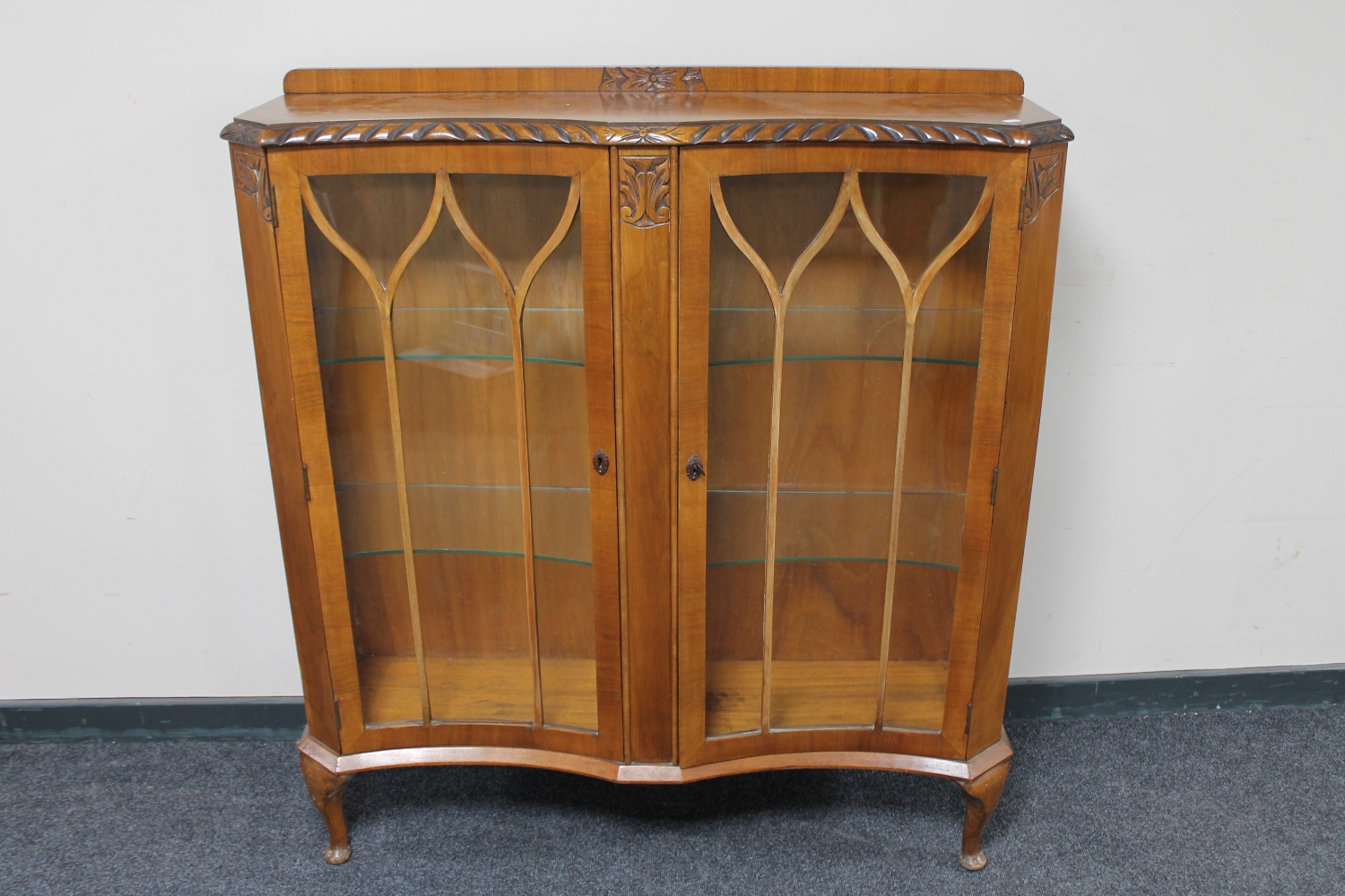 A 1930's walnut shaped fronted display cabinet
