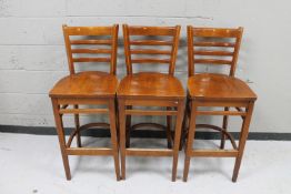 A set of three wooden bar chairs