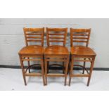 A set of three wooden bar chairs