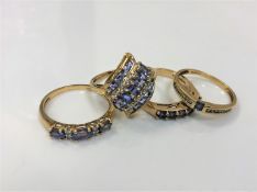 Four 9ct gold dress rings set with gemstones manufactured by QVC, 8.6g gross.