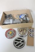 A box of a collection of vintage car badges with fittings