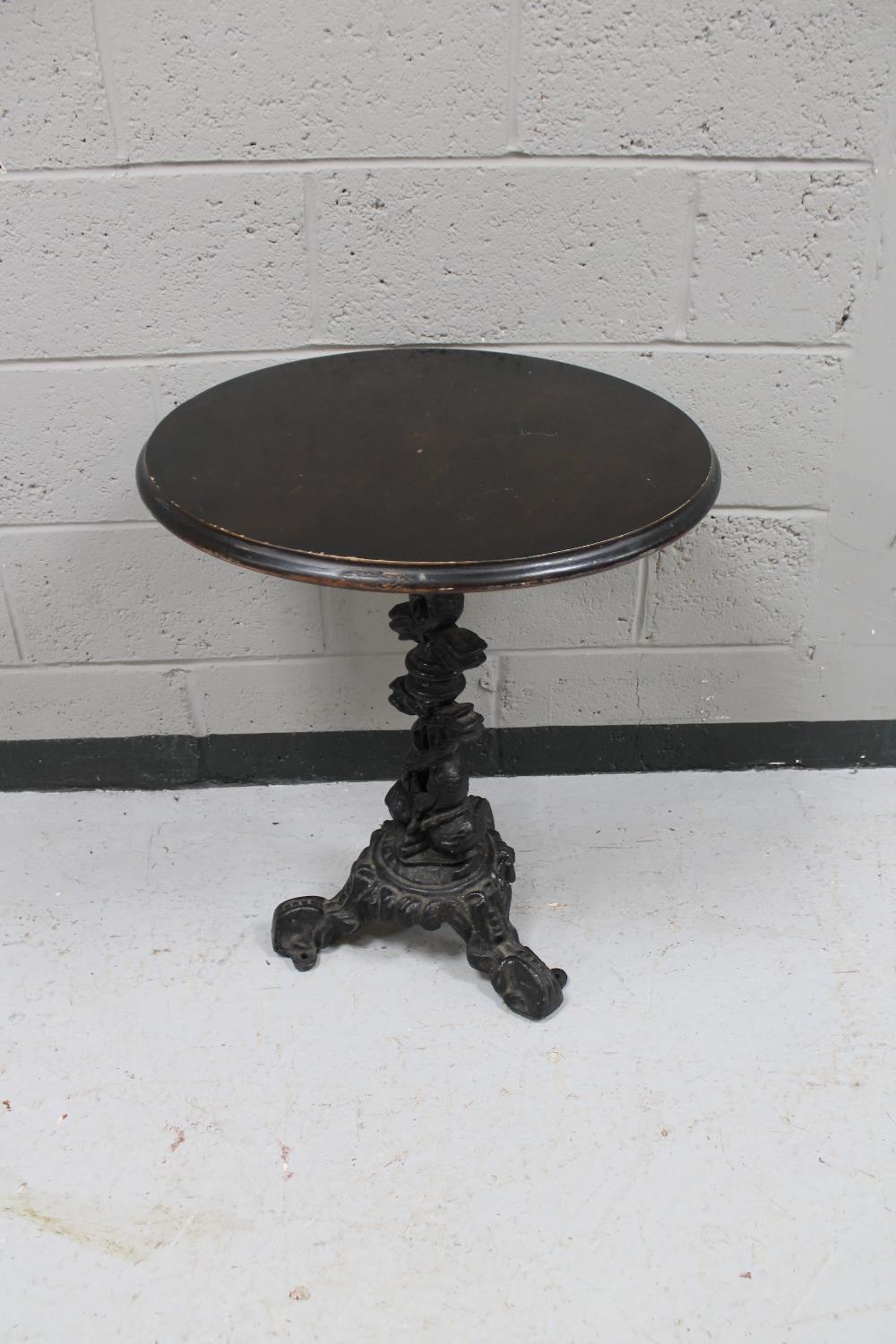 A cast iron bar table with oak top