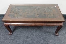 A carved hardwood Chinese style glass topped coffee table