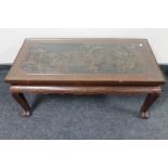 A carved hardwood Chinese style glass topped coffee table