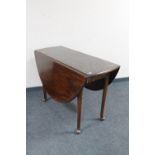 An antique mahogany drop leaf table on club feet