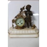 A continental gilt figural mantel clock of a cherub with enamelled dial on marble base