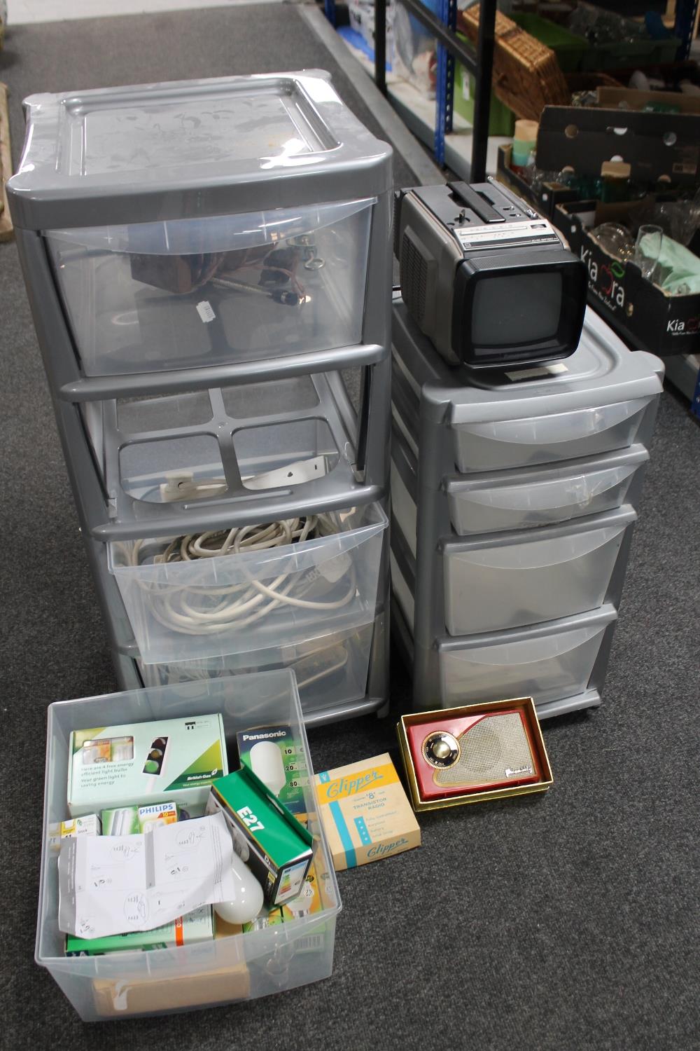 Two plastic storage chests containing extension leads, remote controls,