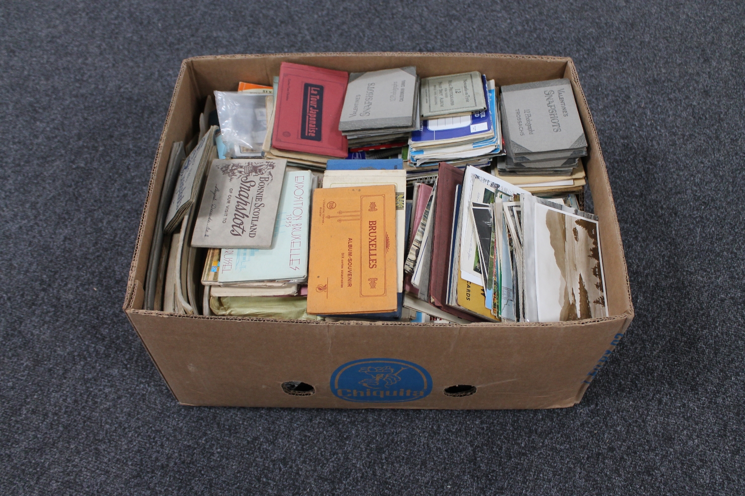 A box of large quantity of antique and later postcards and postcard snap shot books