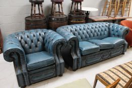 A blue buttoned leather Chesterfield three seater club settee and matching armchair