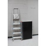 A set of aluminium step ladders and a folding trestle table