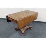 A Victorian mahogany drop leaf pedestal dining table fitted a drawer