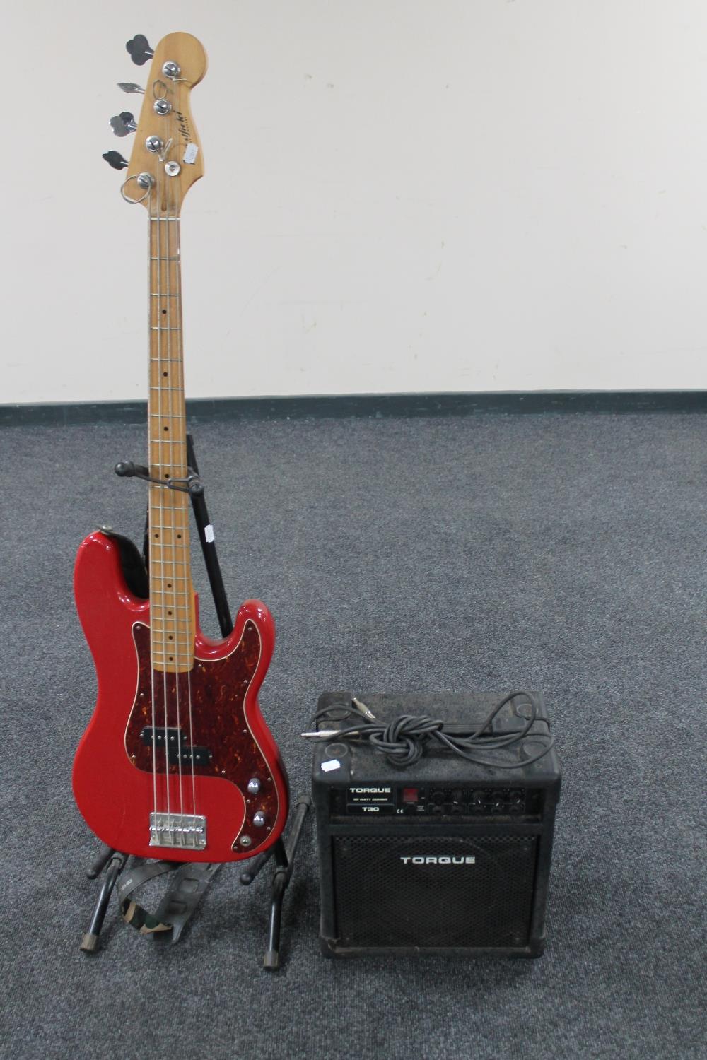 A Westfield bass guitar on stand with a Torque T30 amplifier