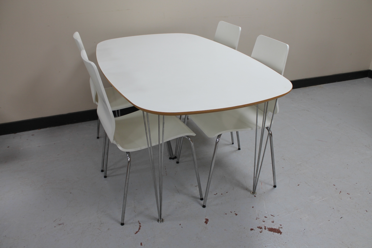 An Ikea dining table on metal hair pin legs and four dining chairs