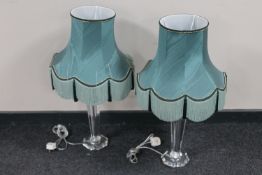 A pair of clear perspex table lamps with green tasselled shades