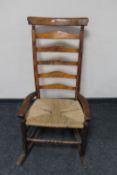 An antique pine rush seated rocking chair