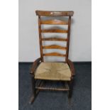 An antique pine rush seated rocking chair