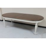 An oval dining table on painted base