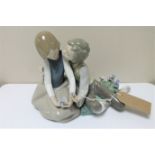 A Lladro figure of young lovers seated with flowers