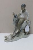 A Spanish china figure : A Young Boy Sitting on a Donkey Alongside a Puppy Dog, no stamp to base,