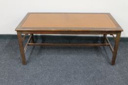 A rectangular mahogany coffee table with tooled brown leather inset panel